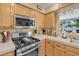 The kitchen features wood cabinets, stainless steel appliances, and a view to the living room at 7950 W Flamingo Rd # 1003, Las Vegas, NV 89147