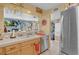 Kitchen sink with view to living room has wooden cabinets, stainless steel appliances, and tiled flooring at 7950 W Flamingo Rd # 1003, Las Vegas, NV 89147