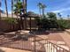 The backyard has mature palm trees, a thatch roof gazebo, and desert landscaping at 8209 Chapelle Ct, Las Vegas, NV 89131