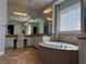 Bright and airy bathroom featuring a large mirror, bathtub, and tiled floor at 8209 Chapelle Ct, Las Vegas, NV 89131