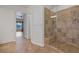 Bright bathroom featuring a tiled shower with a glass door and a neutral-toned tile floor at 8209 Chapelle Ct, Las Vegas, NV 89131