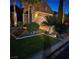 Beautifully landscaped front yard with decorative rock, trees, and lush green grass leading to the garage at 8209 Chapelle Ct, Las Vegas, NV 89131