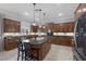 Gourmet kitchen featuring dark wood cabinets, granite countertops, stainless appliances, and a center island at 8209 Chapelle Ct, Las Vegas, NV 89131
