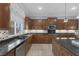 Kitchen features dark wood cabinets, granite counters, stainless appliances, and a view of the backyard at 8209 Chapelle Ct, Las Vegas, NV 89131