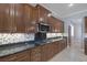 Stylish kitchen with dark wood cabinetry, granite countertops, stainless appliances, and an island cooktop at 8209 Chapelle Ct, Las Vegas, NV 89131