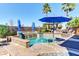 Outdoor pool with umbrella, chairs, and waterfall feature for a relaxing oasis at 8209 Chapelle Ct, Las Vegas, NV 89131