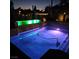 Backyard swimming pool at night with LED lights, surrounded by desert landscaping and exterior lighting at 8209 Chapelle Ct, Las Vegas, NV 89131