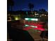Nighttime view of the backyard pool featuring neon lights, tropical palm trees, and privacy landscaping at 8209 Chapelle Ct, Las Vegas, NV 89131