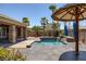 Beautiful pool area with palm trees, decorative umbrellas and a covered patio at 8209 Chapelle Ct, Las Vegas, NV 89131