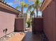 Side yard featuring tile walkway, decorative metal gate, and stone ground cover at 8209 Chapelle Ct, Las Vegas, NV 89131