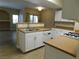 Open kitchen layout with white cabinetry, tile floors and a view of the living area at 8250 N Grand Canyon Dr # 1121, Las Vegas, NV 89166