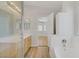 Bright bathroom featuring a tub, wooden cabinets, and modern lighting at 830 Binbrook Dr, Henderson, NV 89052