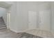 Entryway with tile and wood floors leading to a staircase and featuring white doors and trim at 830 Binbrook Dr, Henderson, NV 89052