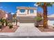 Two-story home featuring a well-kept front yard, attached two-car garage and a desert style landscape at 830 Binbrook Dr, Henderson, NV 89052