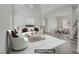 Staged living room featuring gray wood floors, high ceilings, white sofa and chairs, and a modern gold coffee table at 830 Binbrook Dr, Henderson, NV 89052