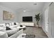 Living room with hardwood floors, a ceiling fan, a comfortable sofa with throw pillows, and a large flat screen television at 830 Binbrook Dr, Henderson, NV 89052