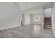 Spacious living room with wood floors, a stairway, and an adjacent dining room featuring a chandelier at 830 Binbrook Dr, Henderson, NV 89052