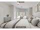 Main bedroom with natural light, a dresser, sitting area, and a large comfortable bed with neutral toned pillows at 830 Binbrook Dr, Henderson, NV 89052