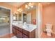 Bright bathroom features a double sink vanity with tiled floors and an adjacent toilet at 8454 Mondavi Hill Ct, Las Vegas, NV 89139