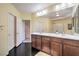 Bathroom featuring double sinks, dark wood cabinets, and a large mirror for a luxurious feel at 8454 Mondavi Hill Ct, Las Vegas, NV 89139