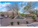 Private backyard boasts a rock water feature, mature trees, landscape lighting, and lounge area at 8824 Prague Ct, Las Vegas, NV 89147
