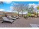 Secluded backyard oasis featuring a rock waterfall feature, mature landscaping, and lounge seating at 8824 Prague Ct, Las Vegas, NV 89147