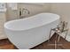 Close-up of a soaking tub with a small table and hardwood floors at 8824 Prague Ct, Las Vegas, NV 89147