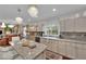 Bright kitchen with granite countertops, dual chandeliers, and views of the dining room and outdoor scenery at 8824 Prague Ct, Las Vegas, NV 89147