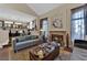 Comfortable living room featuring a fireplace, a velvet sofa, and natural light at 8824 Prague Ct, Las Vegas, NV 89147