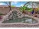 Backyard rock water feature with mature landscaping and sitting area, perfect for relaxing outdoors at 8824 Prague Ct, Las Vegas, NV 89147