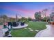 Stunning backyard with manicured lawn, outdoor seating around a fire pit, and ample space for entertaining at 9 Contra Costa Pl, Henderson, NV 89052