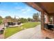 An outdoor covered patio with seating and views of the manicured backyard at 9 Contra Costa Pl, Henderson, NV 89052