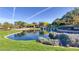 Beautiful view of the Anthem Country Club entrance featuring a pond, waterfall, and lush landscaping at 9 Contra Costa Pl, Henderson, NV 89052