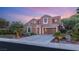 A beautiful two-story home with a three-car garage, landscaped front yard, and warm exterior lighting at 9 Contra Costa Pl, Henderson, NV 89052