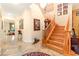 Elegant foyer with wooden staircase, marble floors, and decorative art at 9 Contra Costa Pl, Henderson, NV 89052