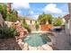 Backyard pool featuring rock waterfall, surrounded by mature trees and greenery, offers a private retreat at 9416 Rolling Ridge Ln, Las Vegas, NV 89134