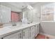 Bright bathroom featuring double sinks, a large mirror, and decorative hardware at 9416 Rolling Ridge Ln, Las Vegas, NV 89134