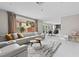 Open concept living room with a modern sofa and a kitchen view at 9416 Rolling Ridge Ln, Las Vegas, NV 89134
