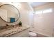 Bright bathroom featuring granite countertop, framed mirror, tiled shower, white cabinets and modern fixtures at 9750 W Cherokee Ave, Las Vegas, NV 89147