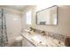 Stylish bathroom with granite countertop, modern fixtures, framed mirror, tiled shower and white cabinets at 9750 W Cherokee Ave, Las Vegas, NV 89147