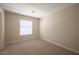 Clean, carpeted bedroom with a large window providing natural light and neutral walls, offering a calming atmosphere at 9750 W Cherokee Ave, Las Vegas, NV 89147