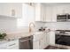 Charming kitchen with white cabinets, granite countertops, subway tile backsplash, and modern appliances at 9750 W Cherokee Ave, Las Vegas, NV 89147