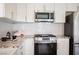 Modern kitchen with stainless steel appliances, granite countertops, and white cabinetry at 9750 W Cherokee Ave, Las Vegas, NV 89147