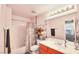 Bright bathroom features a shower-tub combo with curtain, a vanity with mirror, and stacked folded towels at 9879 Jazzy June St, Las Vegas, NV 89183