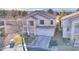 A quaint two-story home, showcasing a tidy yard and a convenient two-car garage, captured from an aerial perspective at 9879 Jazzy June St, Las Vegas, NV 89183