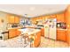 Bright kitchen with wooden cabinets, stainless steel appliances, an island with seating, and tile floors at 9879 Jazzy June St, Las Vegas, NV 89183