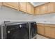 Spacious laundry room featuring modern washer and dryer units with storage cabinets at 134 Wentworth Dr, Henderson, NV 89074