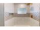 A stylish bathroom featuring hexagon wall tiles, a glass block window, and a decorative accent border at 1801 Griffith Ave, Las Vegas, NV 89104