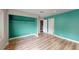 An open-concept bedroom featuring laminate floors, a large closet, and light blue-green painted walls at 1801 Griffith Ave, Las Vegas, NV 89104