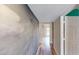 Bright hallway with contemporary gray accent wall and wood-look flooring, providing a modern and inviting transition between rooms at 1801 Griffith Ave, Las Vegas, NV 89104